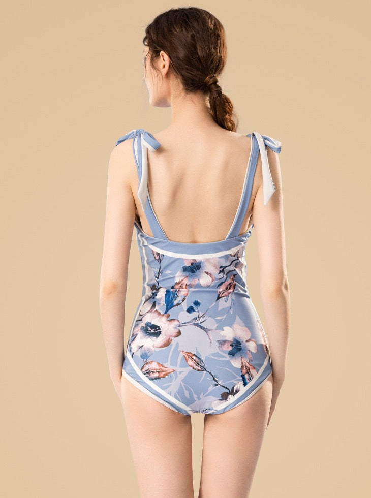 Blauer Badeanzug mit Blumenmuster und Schleifen an den Schultern 